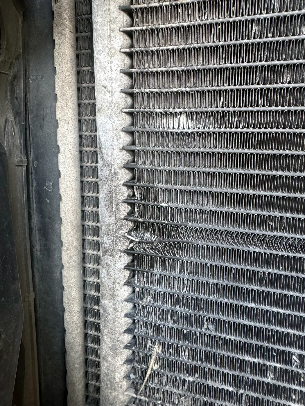 Detail poškození za předním nárazníkem při kontrole vozu